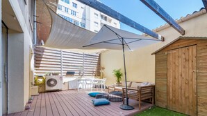 A wooden deck with a table and chairs, a small garden area with artificial grass, and a wooden shed. - Appartement Charles - Welkeys (Marseille)