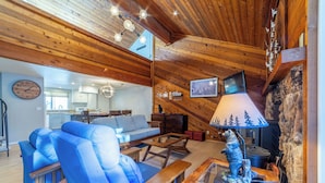 A cozy living room with a blue sofa, wooden coffee table, and a fireplace.