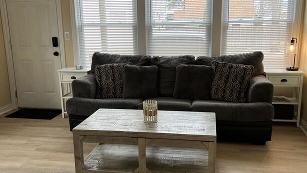 Un salon avec un canapé, une table basse et une porte.