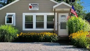 Un petit bâtiment d’un seul étage, sur lequel est apposée une enseigne indiquant « Sunset Vacation Rentals ».