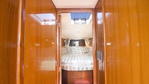 Um interior compacto e bem iluminado, com uma cama, um pequeno espaço de estar e um claraboia.