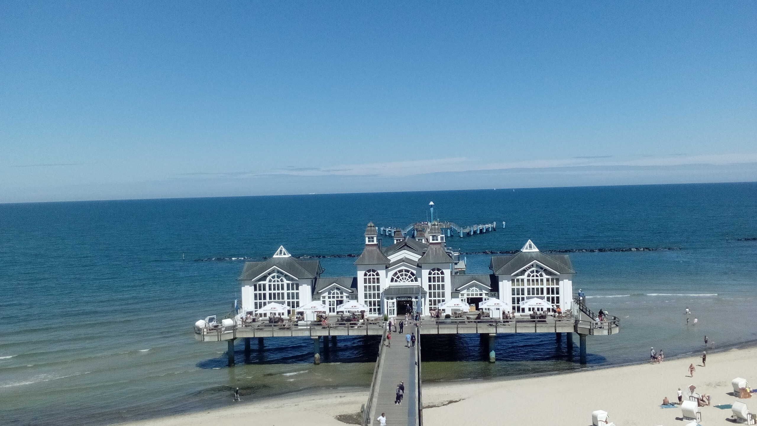 A pier with a white building featuring multiple windows and a central entrance.
