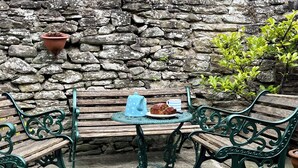A stone wall, a wooden bench, a metal table, and a potted plant. - Pretty cottage, perfect readers' retreat in centre of Hay, parking & fast wifi (Hay-on-Wye)
