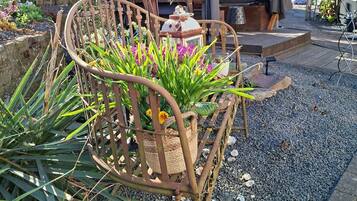 Ein Gartenbereich mit einem Metallstuhl, einer Holzpergola und einem kleinen Tisch.