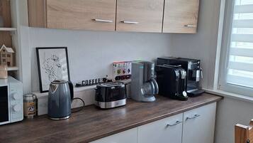 Eine Küche mit Holzausstattung, einer Kaffeemaschine, einem Toaster und einem Wasserkocher.