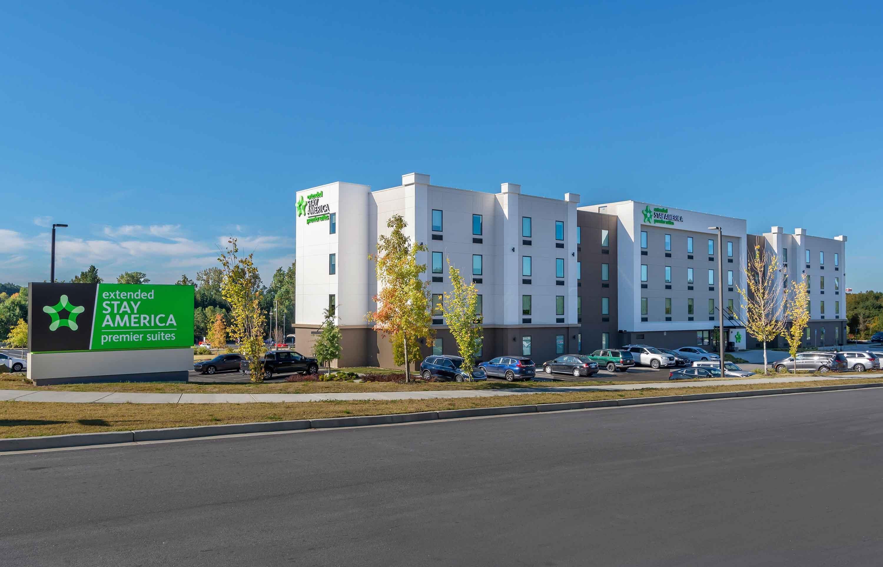 A multi-story hotel with a sign for 'extended STAY AMERICA premier suites.'