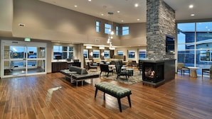 A spacious lobby with a stone fireplace, comfortable seating, and large windows offering views.