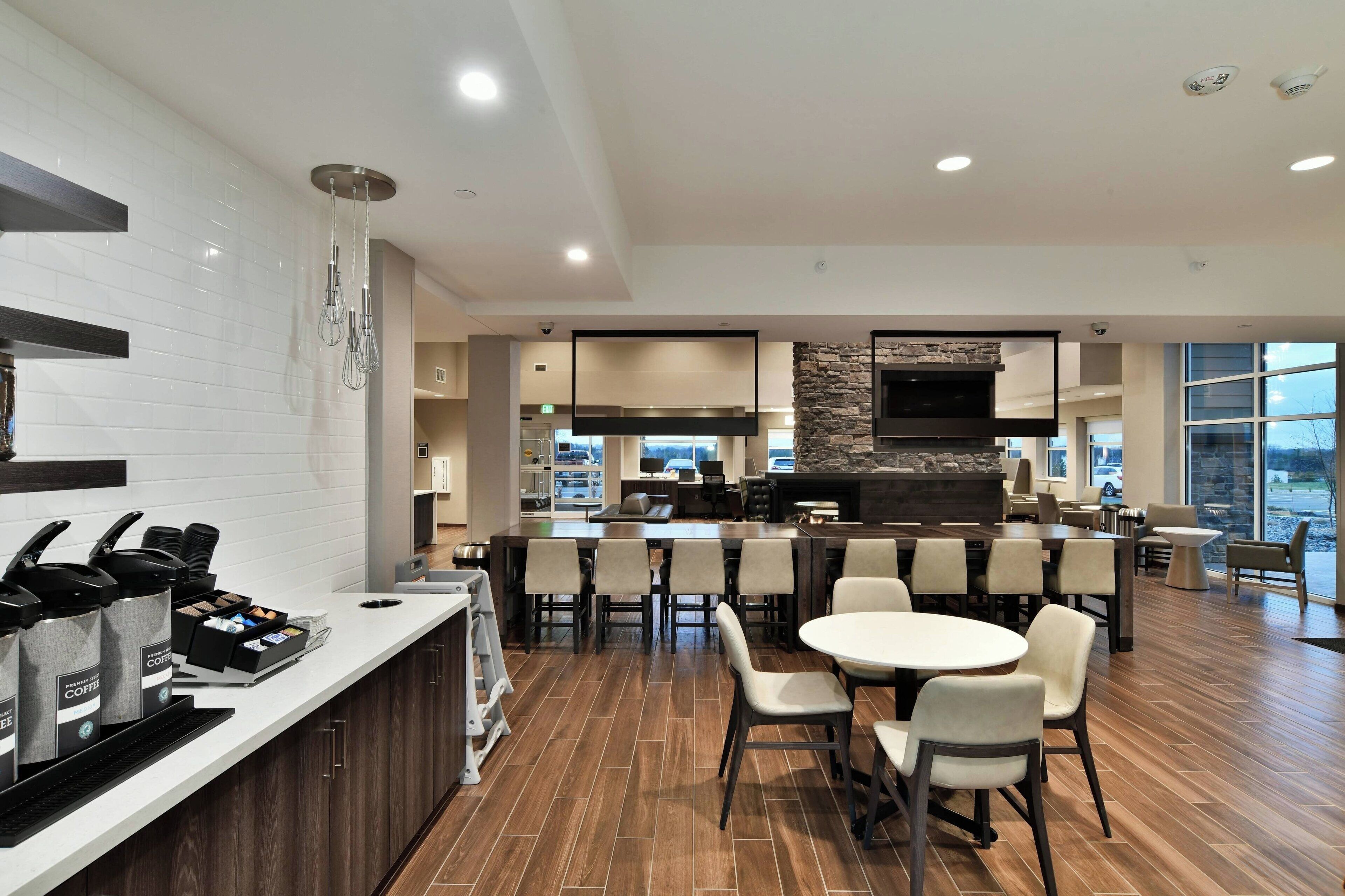 A modern kitchen with a central island, bar seating, and a dining area with chairs.