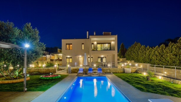 A modern two-story house with a swimming pool, outdoor seating, and well-lit surroundings. - Villa Abelizia with private pool (Chania)
