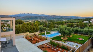 A rooftop terrace with a swimming pool, seating area, and a view of the surrounding landscape. - Villa Abelizia with private pool (Chania)