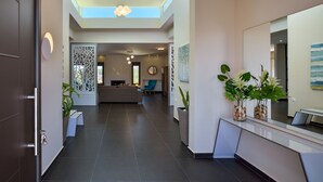 A modern interior with a reception desk, seating area, and a skylight. - Villa Abelizia with private pool (Chania)