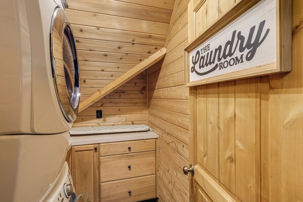 Un lavadero con paredes de madera, una lavadora y un letrero que dice "The Laundry Room".