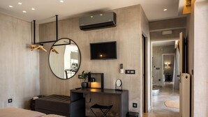 A modern bedroom with a bed, desk, and TV. - Luxe Coastal Escape with Sea Views - Kumo Villa I (Rethymno)