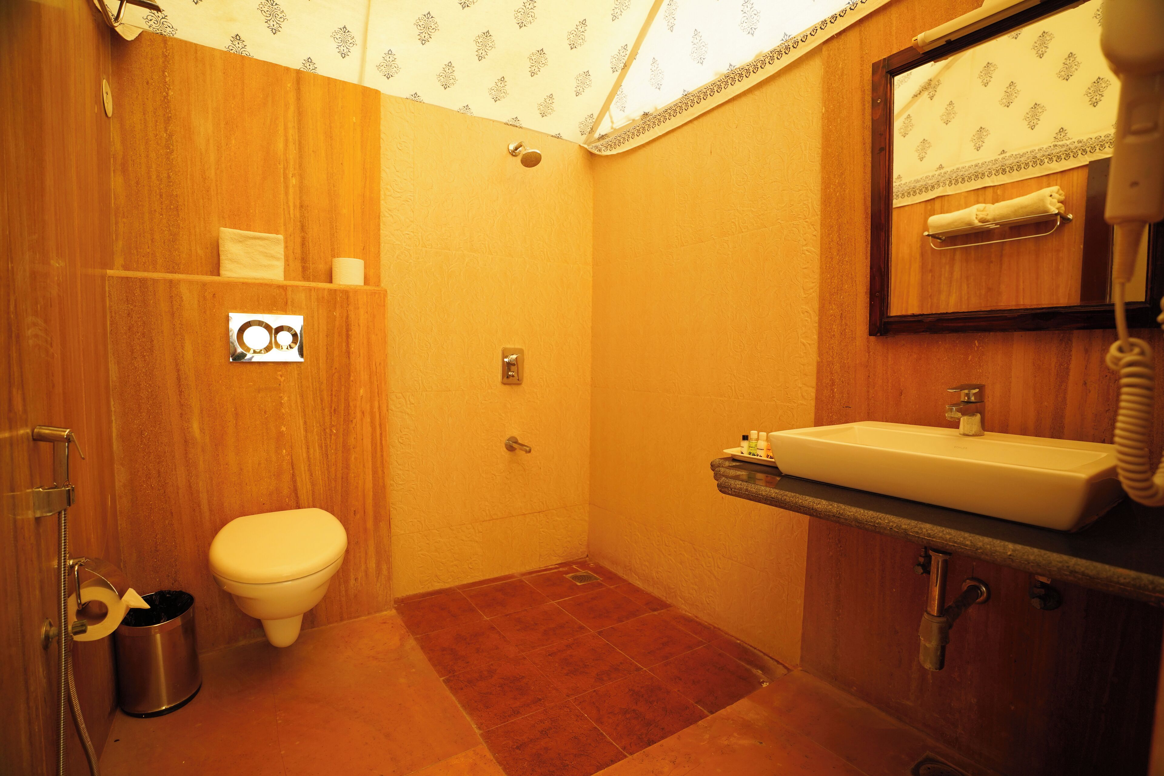 A compact bathroom with a toilet, sink, and shower.