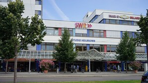 A modern building with signage for SWR and Studio Heilbronn. - Stadtpension Heilbronn (Heilbronn)