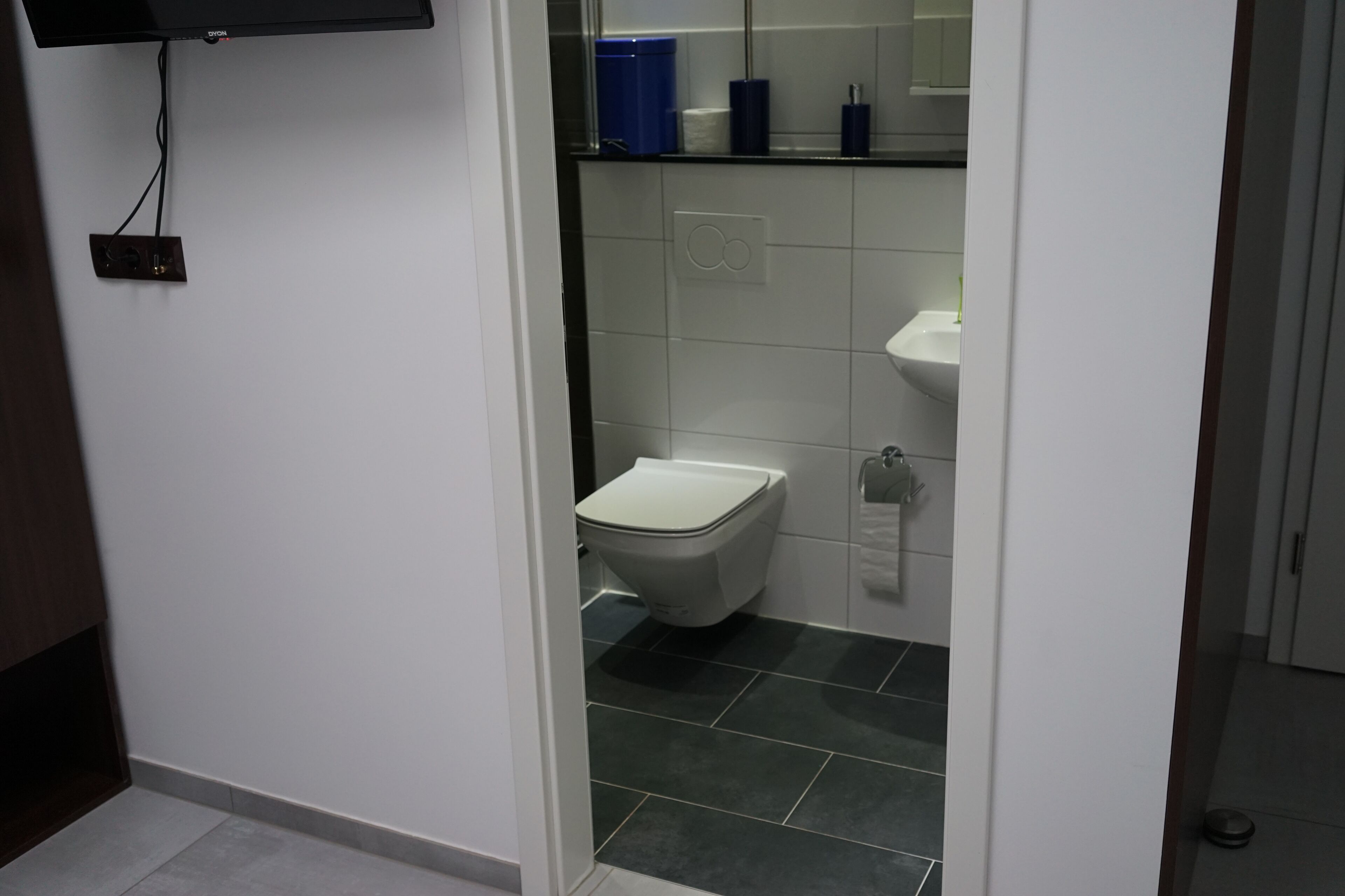 Un baño pequeño y moderno con inodoro, lavabo y espejo.
