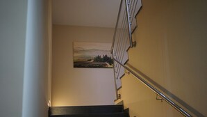 A staircase with a metal handrail and a painting of a landscape on the wall. - Stadtpension Heilbronn (Heilbronn)