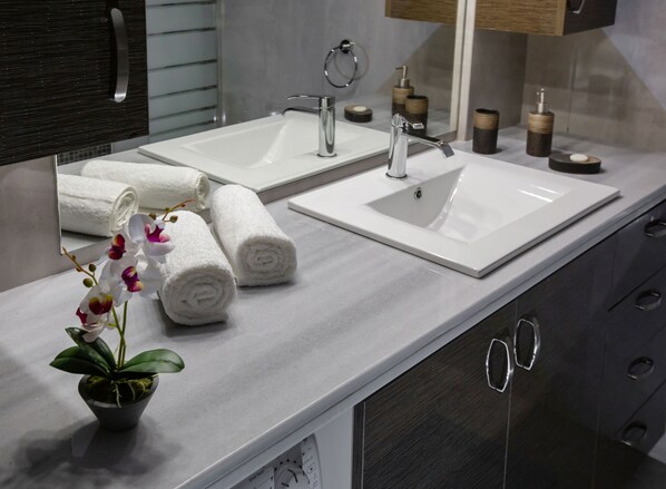 A modern bathroom with two sinks, a mirror, and a potted orchid. - Stunning Apt near Acropolis Museum by GHH (Athens)