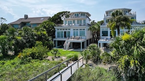 A multi-story beachfront property with a pool, outdoor seating, and lush landscaping. - 28 Carters Manor- Oceanfront Compound, Two Private Pools (Hilton Head Island)