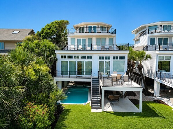A multi-level residential property with a swimming pool, outdoor seating, and lush landscaping. - 28 Carters Manor- Oceanfront Compound, Two Private Pools (Hilton Head Island)