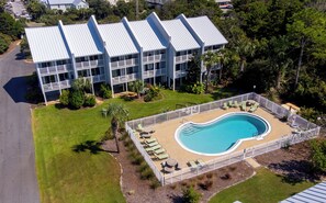 Ein modernes Hotel mit Schwimmbad, mehreren Balkonen und einem gepflegten Rasen.