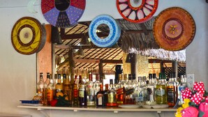 Zona de bar con varias botellas y platos decorativos en la pared.