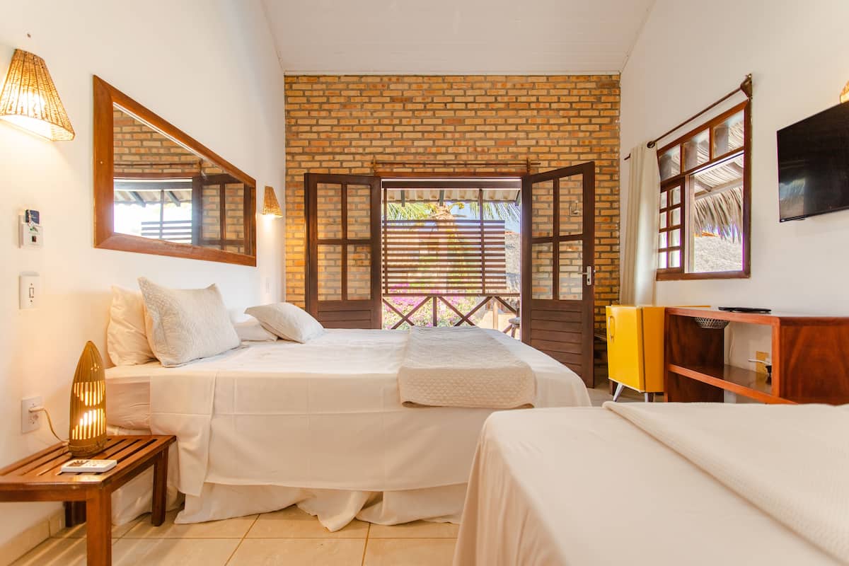 Habitación triple, en la zona del jardín | Minibar, caja fuerte, cortinas opacas y tabla de planchar con plancha