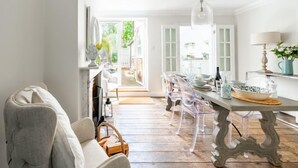 Une cuisine lumineuse et spacieuse, avec un plancher en bois, des chaises transparentes et une table à manger.