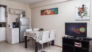 A compact living space with a kitchenette, dining area, and a television. - DEPARTMENT WITH EXCELLENT LOCATION (San Carlos de Bariloche)