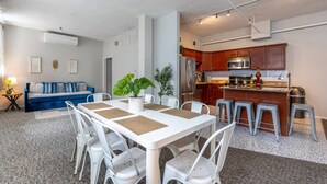 Une cuisine moderne avec des meubles en bois, des appareils en acier inoxydable et un coin bar.
