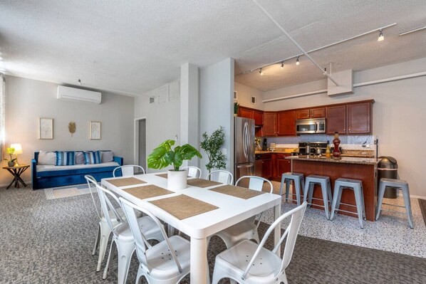 A modern kitchen with wooden cabinets, stainless steel appliances, and a bar area.