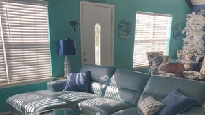 A living room with a sectional sofa, a glass coffee table, and patterned cushions. - SUPER LOCATION, MIDDLE OF THE ISLAND (South Padre Island)
