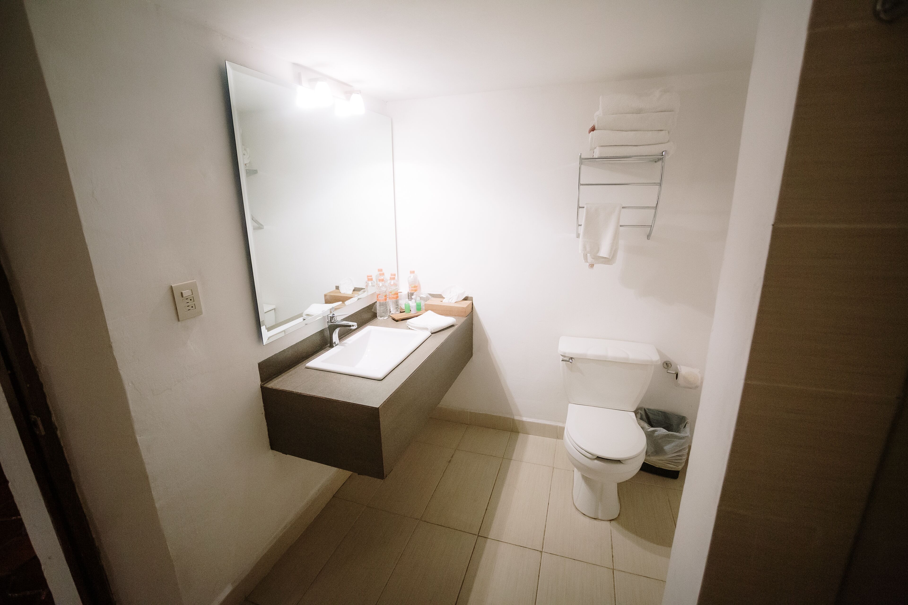 A small bathroom with a sink, mirror, and toilet.