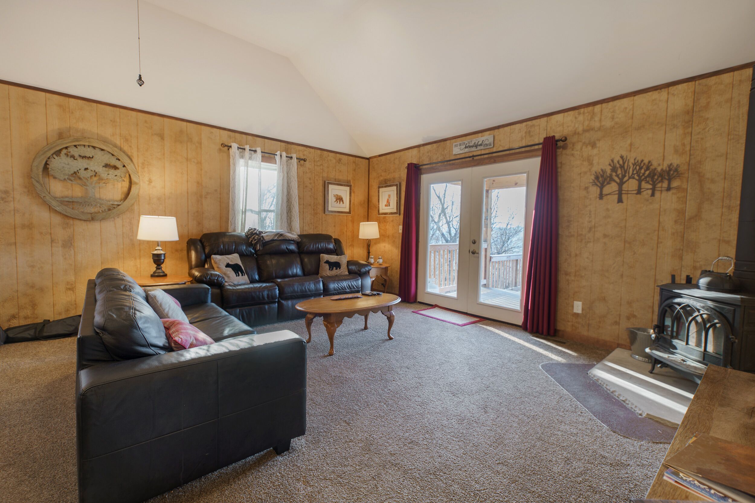 A cozy living room with a leather sofa, a wooden coffee table, and a fireplace.