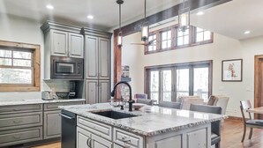 A spacious kitchen with granite countertops, a central island, and a dining area with a large window.