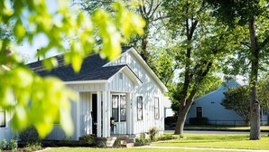 A white single-story house with a front porch, a number '301' on the door, and a tree in the foreground.