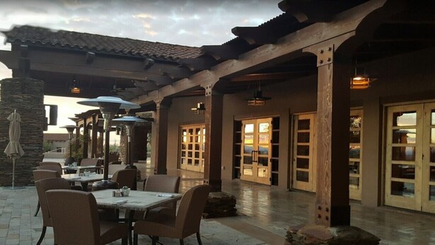 An outdoor patio with tables and chairs, a pergola, and stone pillars. - Dove Mountain Retreat - Private pool (Marana)