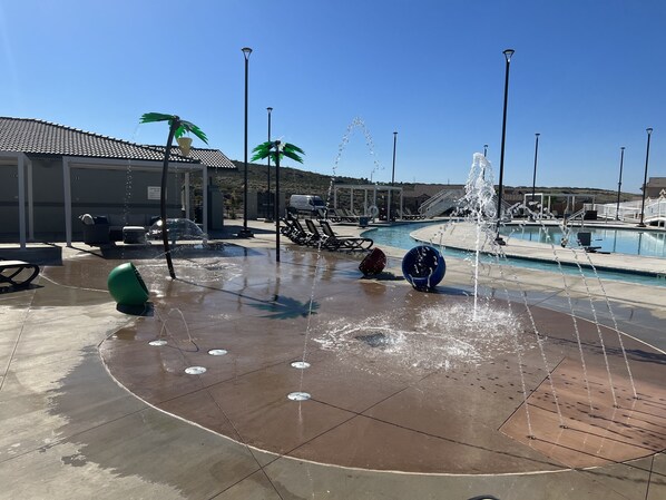 A pool area with water features, lounge chairs, and a covered seating area.