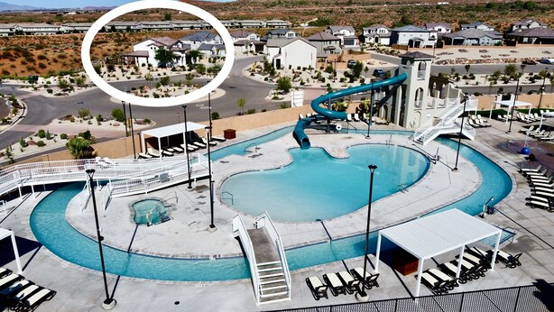 Une piscine avec un toboggan, des chaises longues et un pont piétonnier.