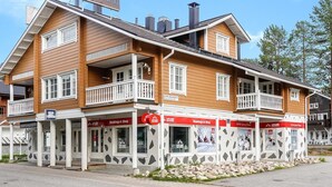 Un edificio de dos pisos con fachada de madera, balcones y un letrero que dice 'Lapland Safaris'.