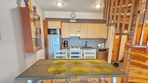 Una cocina compacta con una isla central, microondas, cafetera y lavavajillas.