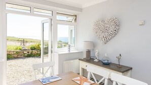 A dining area with a table, chairs, and a view of the outdoors.