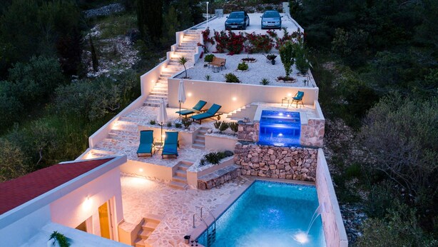A modern outdoor pool area with a stone wall, lounge chairs, and a hot tub. - Villa Likva - Two Bedroom Villa with Private Pool and Hot Tub (Sutivan)
