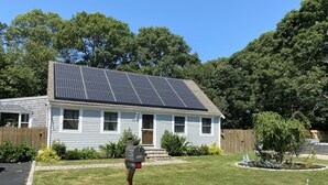A house with solar panels on the roof, a mailbox, and a 'Please keep off grass' sign. - Great Comfortable Private Studio (Barnstable)
