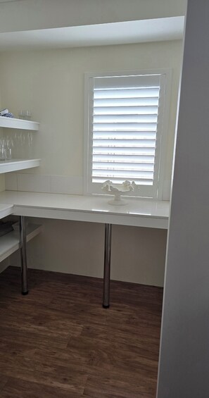 A room with a white desk, a window with blinds, and a wooden floor. - Breath of Fresh Eyre | Walk to Town & Coastal Comfort (Dunsborough)