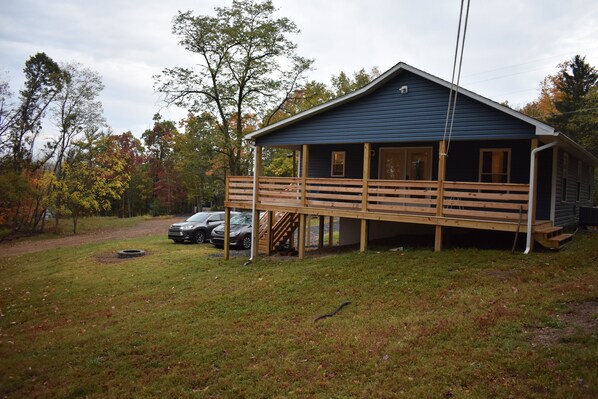 A cabin with a wooden deck, a covered porch, and a garage. - Short walk to the lake! (Huntingdon)