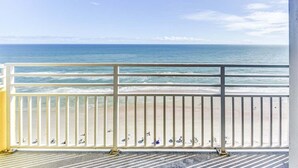 Een balkon met uitzicht op de oceaan en het strand.