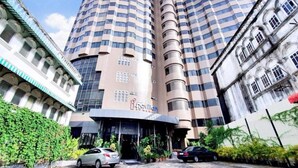 Un hôtel moderne à la façade incurvée, doté de nombreux balcons et d’une entrée imposante.