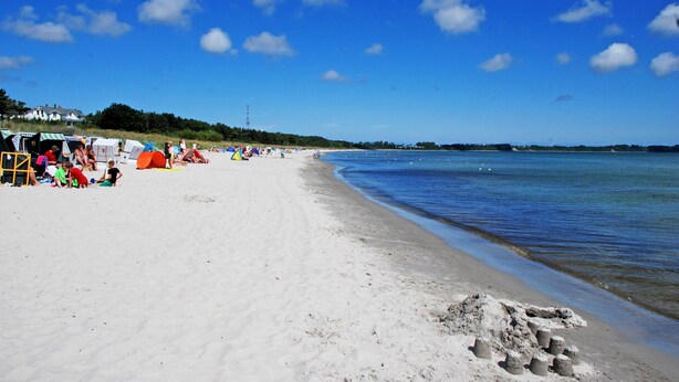 A beach with tents and people, a clear sky, and calm water. - 05 Ferienwohnung Greta mit Balkon - Appartementhaus Greta im Ostseebad (Sellin)