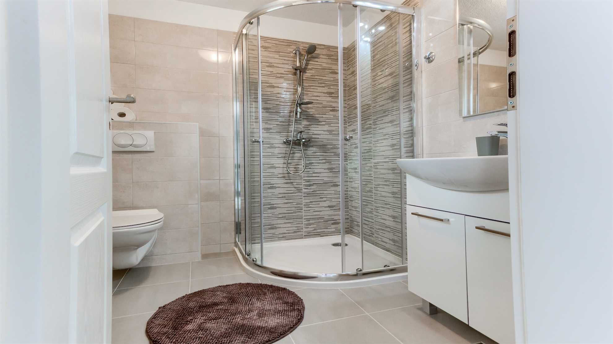 A modern bathroom with a glass-enclosed shower, a toilet, and a sink with a mirror above it.